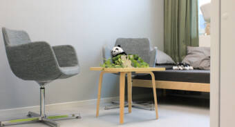 Elevvårdens vilorum med två stolar och en säng. På en av stolarna sitter ett panda mjukisdjur och på sängen ligger ett hund mjukisdjur.
