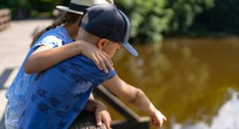 poika ja tyttö katselemassa sillalta Siuntion jokea.