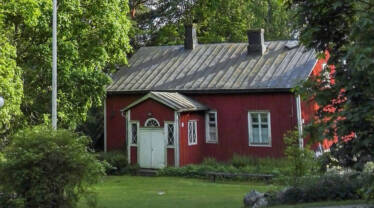 Kotiseutumuseon punainen puutalo valkoisilla ikkunoilla ja pariovella