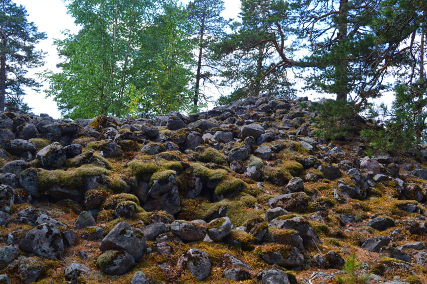En stor hög med stora, delvis mossbeklädda stenar.