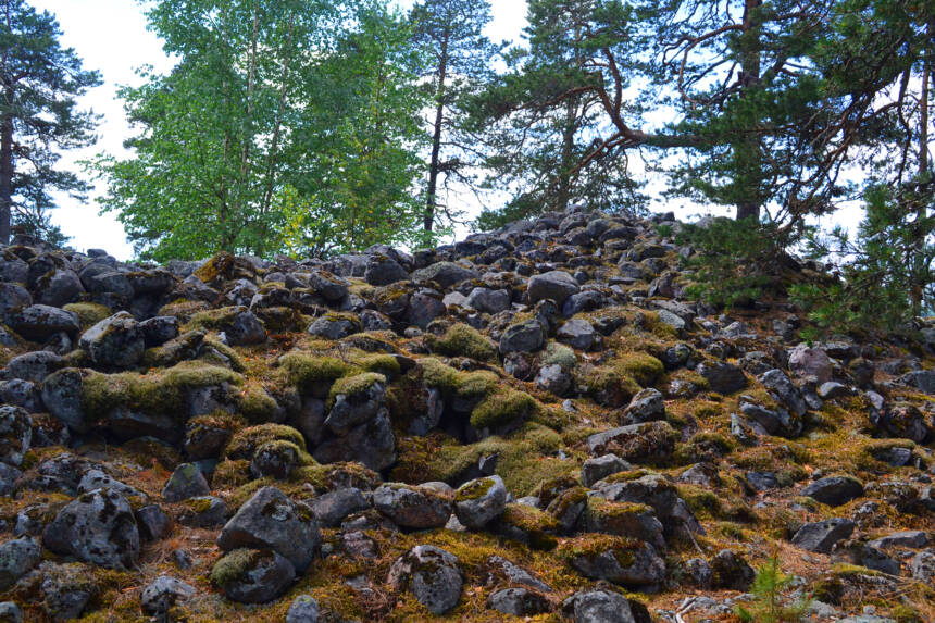 Osittain sammalpeitteinen iso kasa isoja kiviä.