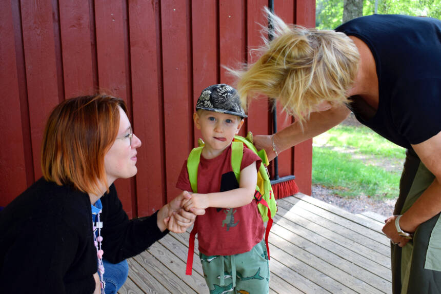 Äiti jättää pienen pojan päiväkodin työntekijälle.