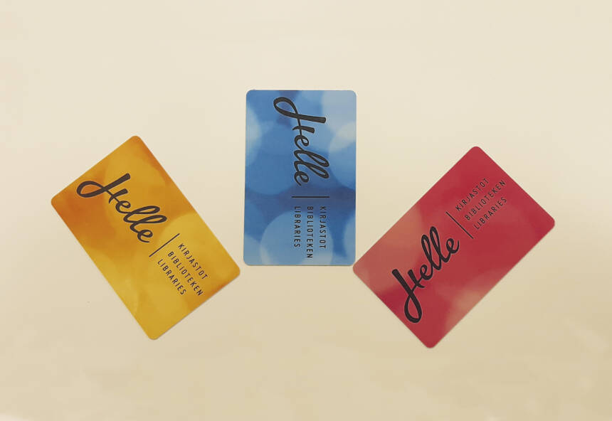 Kolme kirjastokorttia, keltainen, sininen ja punainen.
