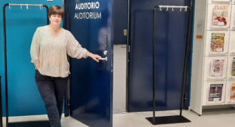 En kvinna håller upp dörren till auditoriet i Bildningscampuset Sjundeå hjärta.