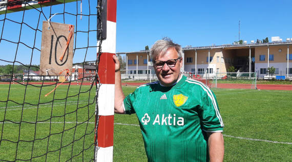 Sjundeå Cupin kilpailunjohtaja Tom K. Laitinen seisoo pelipaidassa käsipallomaalin vieressä Siuntion urheilukentällä.